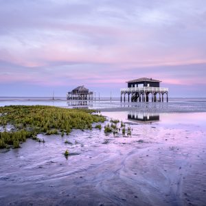 Photo des cabanes tchanquées avec une sublime lumière rose après le coucher de soleil